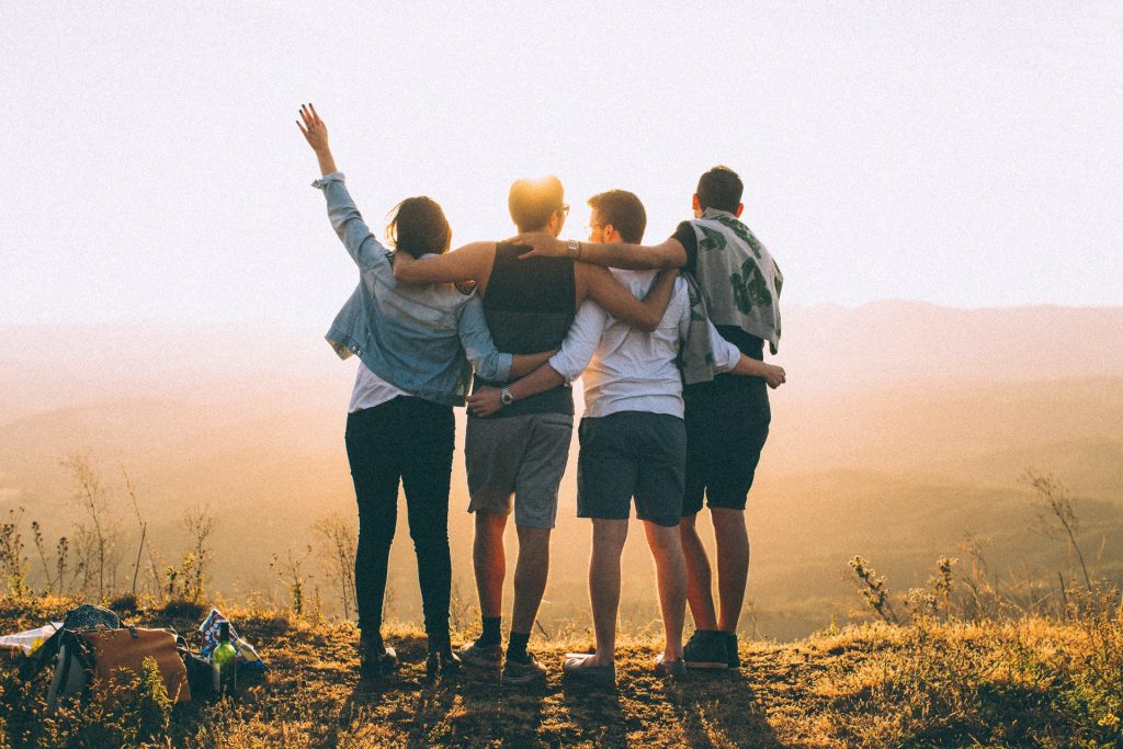 anonymous-friends-standing-together-at-sunset-in-mountains-4453153
